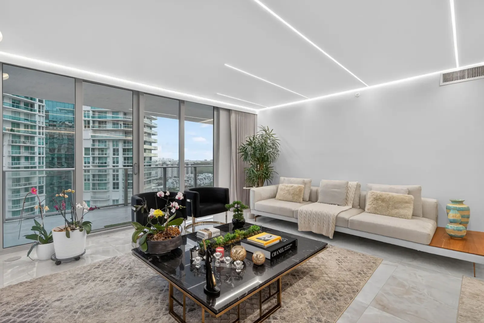 Living room with floor-to-ceiling windows overlooking nearby towers